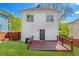 View of the backyard featuring a wood deck, small yard, white siding, and a black entry door at 628 Warren Ave, Scottdale, GA 30079