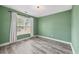 Bedroom with green walls, natural light, and wood-look flooring at 628 Warren Ave, Scottdale, GA 30079