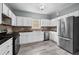 Modern kitchen featuring stainless steel appliances, white cabinets, and stylish backsplash at 628 Warren Ave, Scottdale, GA 30079