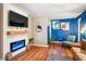 Cozy living room with electric fireplace, wall mounted TV, hardwood floors, and blue accent wall at 877 Lee Andrews Se Ave, Atlanta, GA 30315