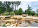 Scenic water feature with a stone bridge and landscaping, creating a tranquil environment at 135 Alcovy Ter, Alpharetta, GA 30009