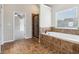 Beautiful bathroom featuring a soaking tub with stylish tile surround and separate shower with glass door at 681 Deer Springs Way, Loganville, GA 30052