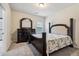 Bright bedroom featuring a classic dark wood bed frame, dresser, and neutral carpet at 681 Deer Springs Way, Loganville, GA 30052