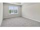 Large bedroom with a large window providing natural light and neutral carpeting at 681 Deer Springs Way, Loganville, GA 30052