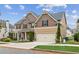 Charming two-story home featuring an attached garage, manicured front lawn, and attractive exterior details at 681 Deer Springs Way, Loganville, GA 30052