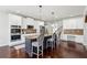 Modern kitchen featuring a center island with bar stools, white cabinets, and stainless steel appliances at 681 Deer Springs Way, Loganville, GA 30052