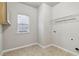 Well-lit laundry room with tiled floor, storage cabinet, and window at 681 Deer Springs Way, Loganville, GA 30052