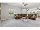 Spacious living room with plush carpeting, a large sectional sofa, and an open view to the kitchen at 681 Deer Springs Way, Loganville, GA 30052