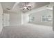 Spacious main bedroom featuring a tray ceiling, large windows, and plush carpeting at 681 Deer Springs Way, Loganville, GA 30052
