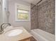 A renovated bathroom featuring a granite countertop, tiled shower, and a chrome faucet at 4309 Gilbert Pl, Forest Park, GA 30297