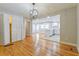 Open living room with wood floors leading to updated kitchen featuring white cabinets and stainless appliances at 4309 Gilbert Pl, Forest Park, GA 30297