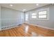 Sun-filled living room featuring wood floors, large windows, and access to stairs at 4309 Gilbert Pl, Forest Park, GA 30297