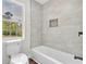 Bathroom featuring modern tub with designer tile and window at 3905 Mill Glen Dr, Douglasville, GA 30135