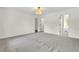 Spacious bedroom with grey carpet, an ornate light fixture, and entry to a full bathroom at 3905 Mill Glen Dr, Douglasville, GA 30135