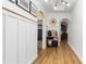 Bright hallway featuring wood floors, arched doorways, decorative accents, and a view into the living spaces at 401 Daffodil Dr, Temple, GA 30179