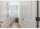 Hallway with laundry closet, featuring wood floors, white cabinets and doors at 401 Daffodil Dr, Temple, GA 30179