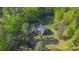 Aerial view of a private home surrounded by lush trees on a sunny day at 5830 Wills Wood Cir, Cumming, GA 30040