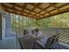 Cozy back porch with white lattice railing and comfortable seating area overlooking the trees at 5830 Wills Wood Cir, Cumming, GA 30040