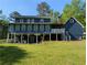 Two-story home with a back deck and porch looking out to the large grassy backyard at 5830 Wills Wood Cir, Cumming, GA 30040