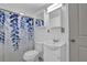 Bathroom features a shower with a blue leaf shower curtain, toilet and sink with vanity at 5830 Wills Wood Cir, Cumming, GA 30040