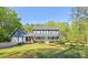 Charming two-story home with a well-manicured lawn and a welcoming front porch in a lush, wooded setting at 5830 Wills Wood Cir, Cumming, GA 30040