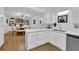Modern kitchen with white cabinetry, stainless steel appliances, and an open layout to the dining room at 5830 Wills Wood Cir, Cumming, GA 30040