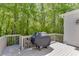 View of the back deck, complete with a grill, with an outdoor wall sconce and landscaping at 7035 W Mountain Xing, Cumming, GA 30041