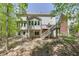 View of the house from the backyard featuring a deck with stairs leading to the lush green space at 7035 W Mountain Xing, Cumming, GA 30041