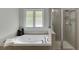 Bathroom featuring a corner tub, tiled shower, and large window at 7035 W Mountain Xing, Cumming, GA 30041