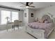 Cozy bedroom with a desk, modern ceiling fan, and large windows providing natural light at 7035 W Mountain Xing, Cumming, GA 30041