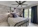 Cozy bedroom featuring a brick accent wall, ceiling fan, and natural light at 7035 W Mountain Xing, Cumming, GA 30041