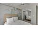 Bright bedroom featuring a custom accent wall, mirrored closet doors, and comfortable bed at 7035 W Mountain Xing, Cumming, GA 30041