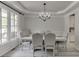 Formal dining room featuring a chandelier, large windows, and seating for six at 7035 W Mountain Xing, Cumming, GA 30041