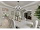 Formal dining room with a stylish chandelier, tray ceiling, and open access to other living spaces at 7035 W Mountain Xing, Cumming, GA 30041