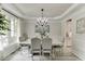 Elegant dining room with a chandelier, wainscoting, and a large window providing natural light at 7035 W Mountain Xing, Cumming, GA 30041