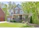 Charming two-story house with stone and siding, lush green lawn, and inviting front entrance at 7035 W Mountain Xing, Cumming, GA 30041