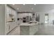 A modern kitchen featuring white cabinets, stone accents, an island, and stainless steel appliances at 7035 W Mountain Xing, Cumming, GA 30041