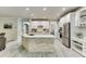 Spacious kitchen features white cabinets, stainless appliances, island with stone accents, and recessed lighting at 7035 W Mountain Xing, Cumming, GA 30041