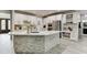 Bright kitchen with white cabinetry, stainless appliances, stone backsplash, and large island with a breakfast bar at 7035 W Mountain Xing, Cumming, GA 30041