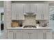 Modern kitchen boasts white cabinets, stainless steel appliances, and stylish stone backsplash at 7035 W Mountain Xing, Cumming, GA 30041