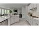 Modern kitchen with white cabinets, stone accents, stainless steel appliances, and an island featuring a sink at 7035 W Mountain Xing, Cumming, GA 30041