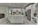 A spacious kitchen featuring a large island with stone accents, stainless steel appliances, and ample storage at 7035 W Mountain Xing, Cumming, GA 30041