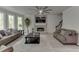Spacious living room with stone fireplace, ceiling fan, large windows, and comfortable seating at 7035 W Mountain Xing, Cumming, GA 30041