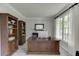 Spacious home office with built-in bookshelves, a large desk, and natural light from the window at 7035 W Mountain Xing, Cumming, GA 30041