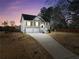 Charming two-story home with a well-manicured lawn and a two-car garage at twilight at 8870 Dornoch Cir, Winston, GA 30187