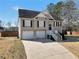 Two-story home with two-car garage featuring a well-lit front entrance and tidy yard at 8870 Dornoch Cir, Winston, GA 30187