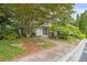 Charming home featuring a lush, tree-covered yard and a welcoming brick path to the front door at 1250 Parkwood Circle Se # 1110, Atlanta, GA 30339