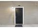 Close-up of the black front door of unit 1110 with a charming overhead light at 1250 Parkwood Circle Se # 1110, Atlanta, GA 30339