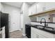 Kitchen features modern appliances, white cabinets, black countertops, and a sleek black sink at 1250 Parkwood Circle Se # 1110, Atlanta, GA 30339
