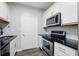 A well-lit kitchen with stainless steel appliances, white cabinets, and a stylish black countertop and sink at 1250 Parkwood Circle Se # 1110, Atlanta, GA 30339